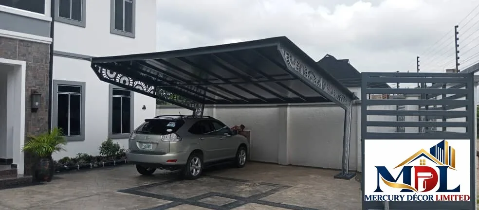 A residential carport with a decorative black steel canopy.