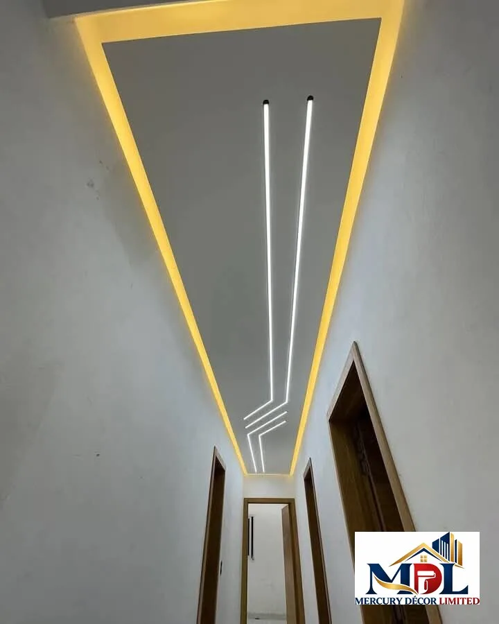A contemporary hallway ceiling with warm cove lighting and linear LED strips.