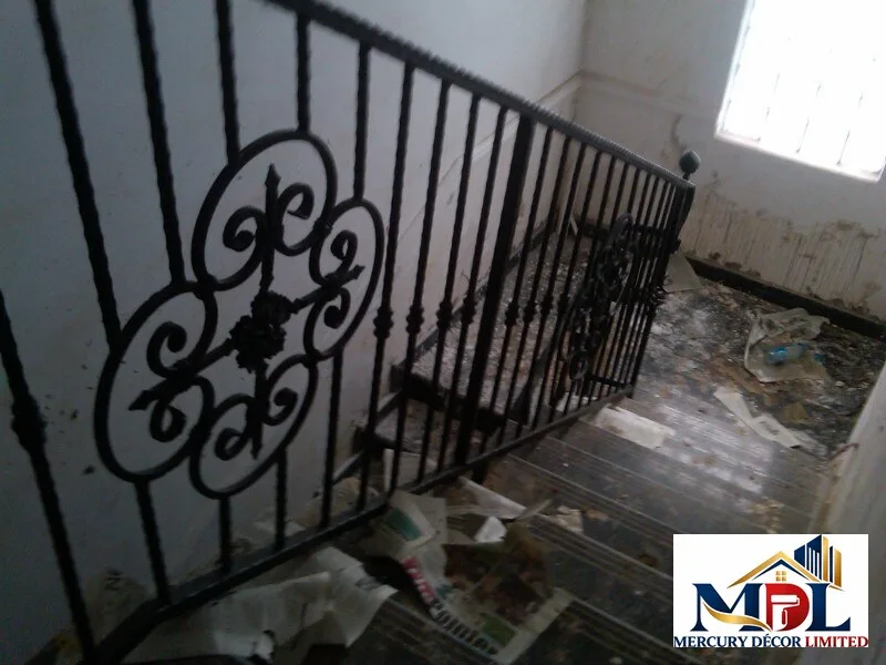 A wrought-iron stair railing with a decorative scroll motif.
